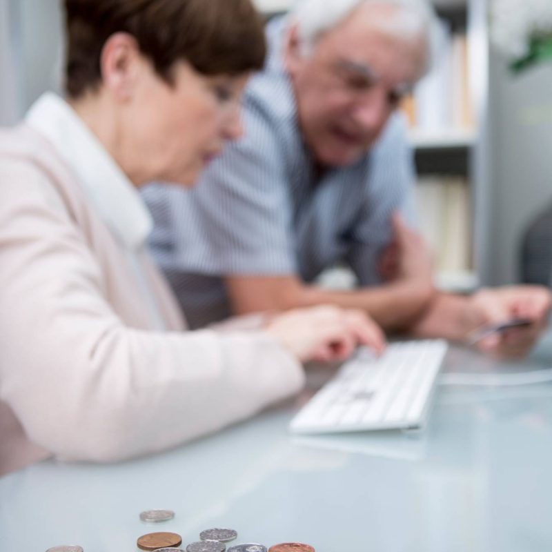 senior-couple-using-computer-with-small-cash-in-fo-2024-09-22-19-17-22-utc_res